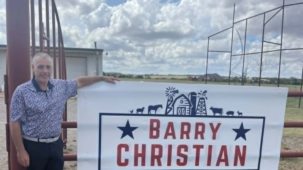 Barry Christian next to campaign sign
